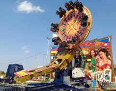 Fahrgeschäft "Crazy Roulette" mit einer Drehscheibe an einer Achse mit Roulette-Aufdruck in Betrieb