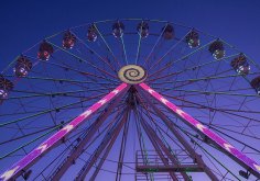 Beleuchtetes Riesenrad bei dämmerndem Abendhimmel