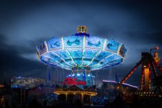 Blau angeleuchtetes Kettenkarussell bei Nacht auf dem Viehmarkt