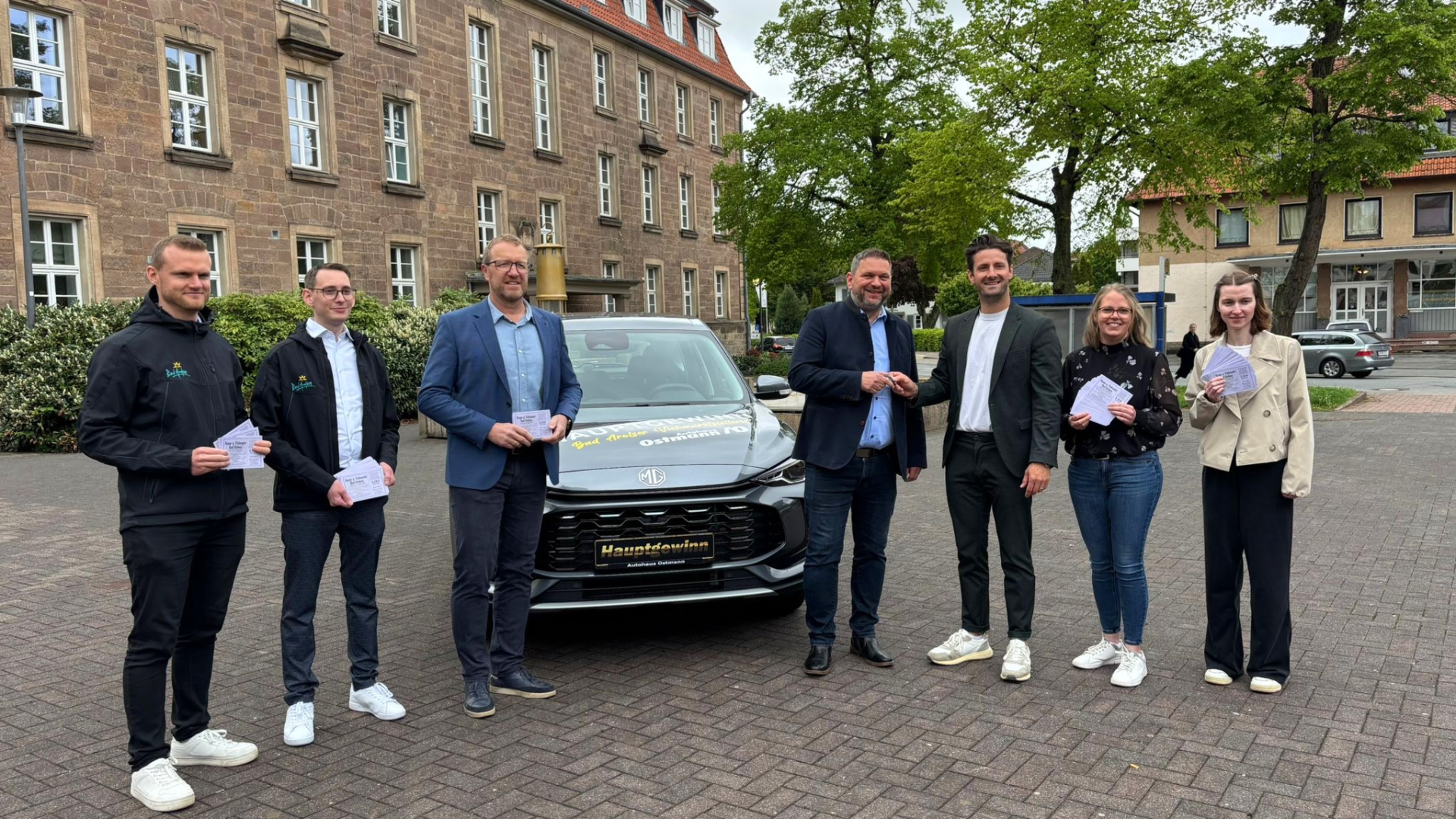 Der Hauptgewinn der Viehmarktslotterie, ein MG ZS in grau, wird gemeinsam mit Bürgermeister Lambion und Autohaus Ostmann präsentiert.