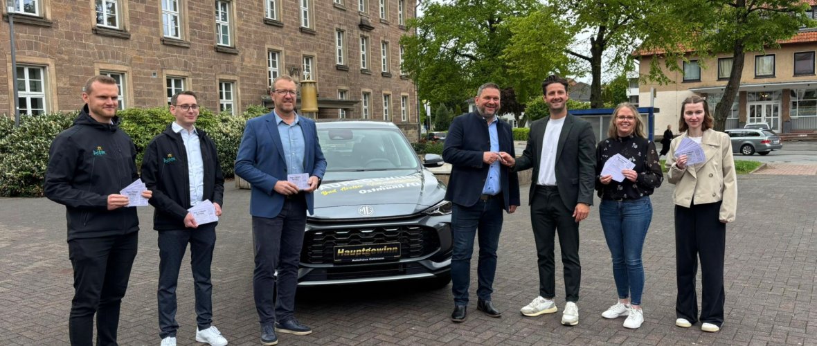 Der Hauptgewinn der Viehmarktslotterie, ein MG ZS in grau, wird gemeinsam mit Bürgermeister Lambion und Autohaus Ostmann präsentiert.